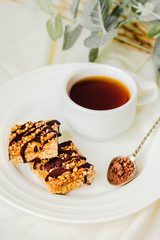 Paleo chocolate energy bars with rolled oats, nuts, dates caramel, chia seeds and coconut flakes on rustic background. Top view.