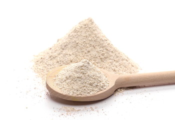Integral barley flour with wooden spoon isolated on white background