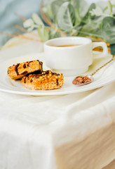 Granola bar with date caramel and chocolate. Healthy sweet dessert snack. Selective focus. A cup of coffee. Healthy breakfast. Copy space for text.