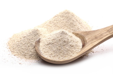 Integral barley flour with wooden spoon isolated on white background