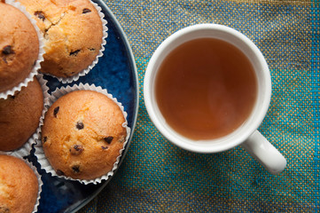 Tea with muffins with chocolate drops. Delicious sweet dessert. Sweetness to tea. Homemade baking. Treats for children. Popular cupcake.