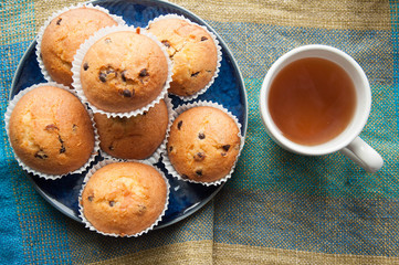 Tea with muffins with chocolate drops. Delicious sweet dessert. Sweetness to tea. Homemade baking. Treats for children. Popular cupcake.