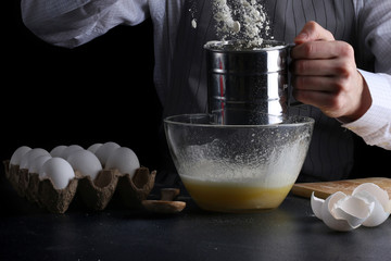 sifting flour in bowl. man cooking dessert concept