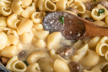 Pasta carbonara with mushrooms is cooked in a pan - Italian cuisine