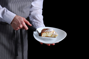 chef serves the pie on dark background. pie recipe concept