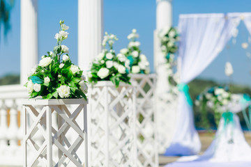 wooden stands and bouquets of flowers in front of the arch