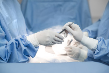 Close up of surgery team operating in operation room in hospital. send a Scalpel.