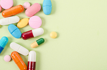 Heap of various pills on color background.