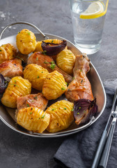 Roasted chicken leg with potatoes cumin and garlic on black background. Copy space.