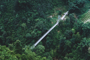 Sapa in Vietnam with a bridge across the ravine in a valley and trees over a river