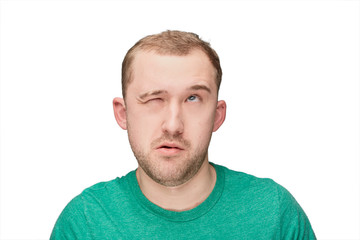 Fototapeta premium Zabawny młody człowiek w zielonej koszuli pokazuje spojrzenie