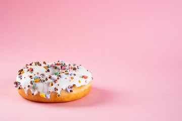 Donuts with icing on pastel pink background. Sweet donuts. Copy space.