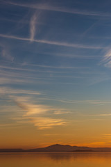 Beautiful view of Trasimeno lake (Umbria, Italy) at sunset, with orange and blue tones in the sky