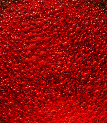 Huge quantity of red air bubbles in liquid.