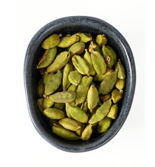 cardamom pods in a black bowl