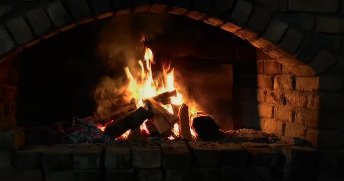 Crackling log fire in a stone fireplace