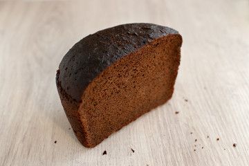 Loaf of black rye bread. Rye bread in the cut. Bread from rye flour close up on a wooden background. Baking for a healthy diet.