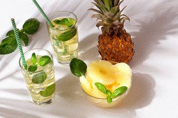 Pineapple juice with palm leaves on white