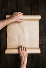 Male hands holding old paper scroll