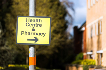 farmacy health centre directional road sign on road in uk