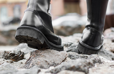 Close up view sole black leather boot on stone nature background outdoor