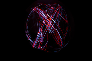 Light painting of continuous red and white spirals forming a chaotic shape. Dynamic time trajectory...