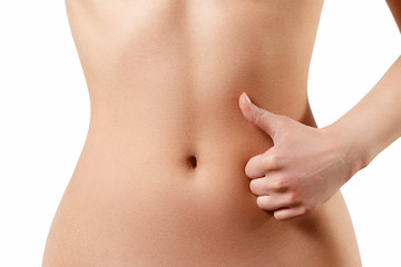 Fototapeta na wymiar slim, athletic waist of a young woman on white background. The hand in the foreground shows a finger up gesture. the concept of female beauty and health, nutrition and diet, beautiful figure