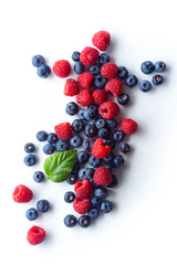 Raspberries and blueberries isolated on white background with copy space