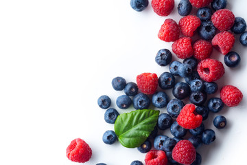 Raspberries and blueberries isolated on white background with copy space