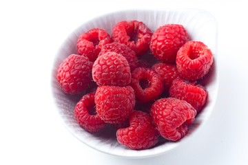 Fresh raspberries in ceramic bowl isolated on white background