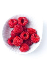Fresh raspberries in ceramic bowl isolated on white background