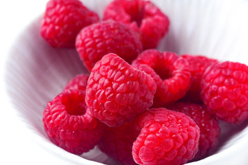 Fresh raspberries in ceramic bowl isolated on white background