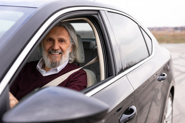 Senior attractive man is driving the car