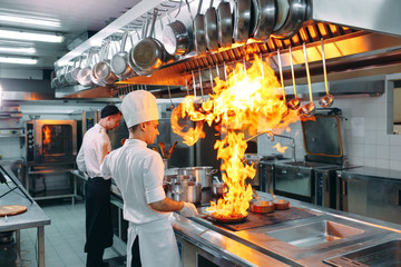 Modern kitchen. Cooks prepare meals on the stove in the kitchen of the restaurant or hotel. The...