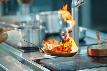 Chef cooking vegetables in wok pan. Shallow dof.