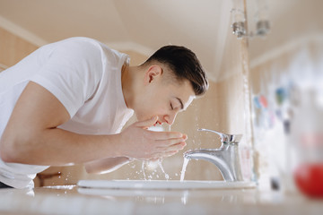 morning hygiene, the boy is washed in a wash basin with spray of water