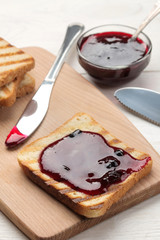 toasts with jam. fried crispy toasts with red jam on a white wooden table. breakfast. close-up