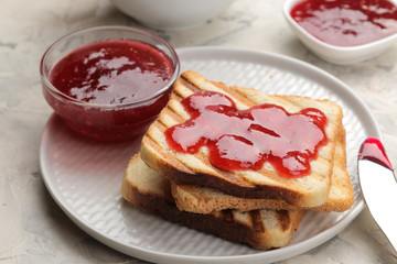 toasts with jam. fried crispy toasts with red jam on a light concrete table. breakfast. close-up