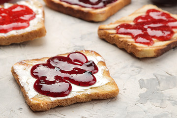 toasts with jam. fried crispy toasts with red jam on a light concrete table. breakfast. close-up