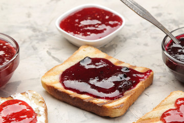 toasts with jam. fried crispy toasts with red jam on a light concrete table. breakfast. close-up