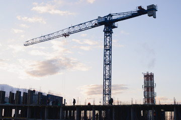 Construction crane on the construction site. Under construction concrete building.