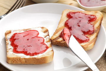 toasts with jam. fried crispy toast with red jam on a natural wooden table. breakfast. close-up