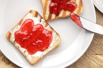 toasts with jam. fried crispy toast with red jam on a natural wooden table. breakfast. top view