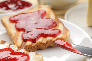toasts with jam. fried crispy toast with red jam on a natural wooden table. breakfast. close-up