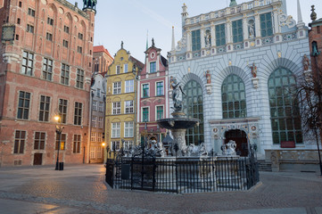 Fototapeta na wymiar Fountain of the Neptune in old town of Gdansk, Poland. Long Lane architecture. Artus Yard and the City Hall.