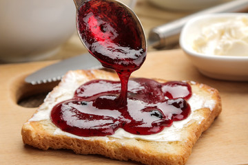 toasts with jam. fried crispy toast with red jam on a natural wooden table. breakfast. close-up