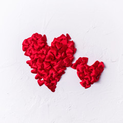 Hearts made from little red textilled hearts  on  white textured  background. St. Valentine Day background.