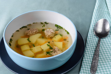 Vegetable soup with chicken cutlets and pieaces of homemade bread.Side view with copy space.