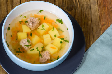 Vegetable soup with chicken cutlets and pieaces of homemade bread.Side view with copy space.