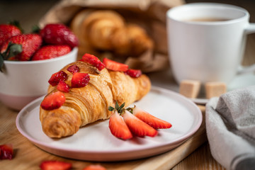 Breakfast concept with coffee cup, croissants, cream and fresh berries